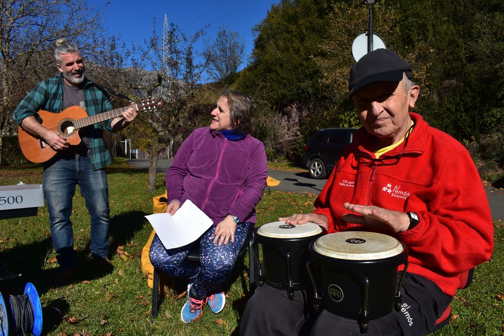 Pablo, con la guitarra; Isabel, cantando, y Ernesto, con los tambores, en un ensayo de la Remós Band en un día soleado en el jardin de el Centro El Remós