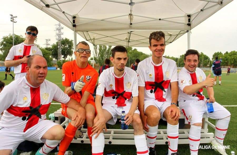 Foto de varios jugadores del equipo de la SD Huesca, vestidos con el uniforme blanco con la cruz de San Jorge y Alberto, con su equipación anranja de portero, durante la concentración Getafe de la Liga Genuine